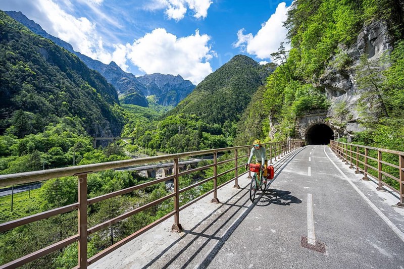 Cyclists with panniers on a cycle path with tunnel, cycle path along the old Pontebba railway line in Eisental, mountain landscape of the Julian Alps, Alpe-Adriatic cycle path, bike packing, Friuli-Venezia Giulia, Italy