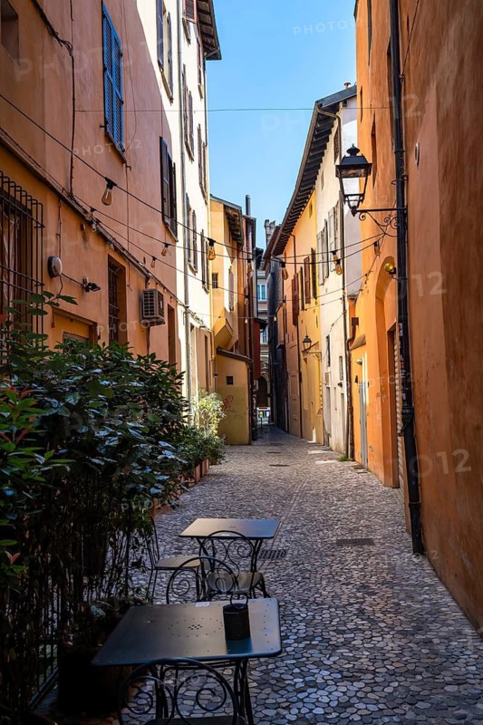 Restaurant in a small alley and with colorful houses, old town, Bologna, Emilia Romagna, Italy