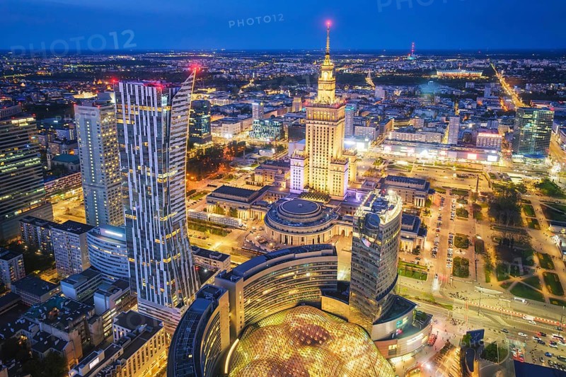 Cityscape view of Warsaw, Poland, with the Palace of Culture landmark, skyline, street perspective, blue hour twilight and city lights