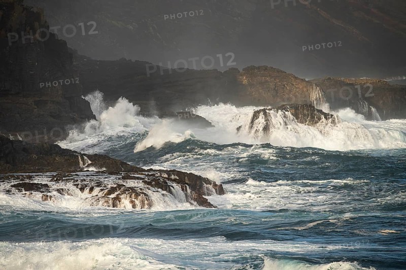Wild sea and high waves on the coast at the La Fajana marine swimming pool. Morning light. La Palma, Canary Islands, Spain