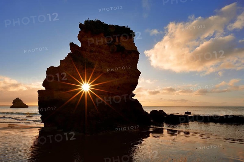 Rocks on beach at sunrise, sun star, Praia Dona Ana, Lagos, Algarve, Portugal