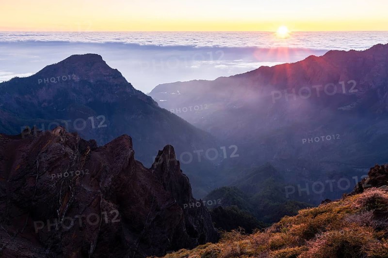 View of the Caldera de Taburiente from Pico de La Nieve at sunset and back light. In the back left, Mount Bejenado. Sun and sea of clouds. La Palma, Canary Islands, Spain