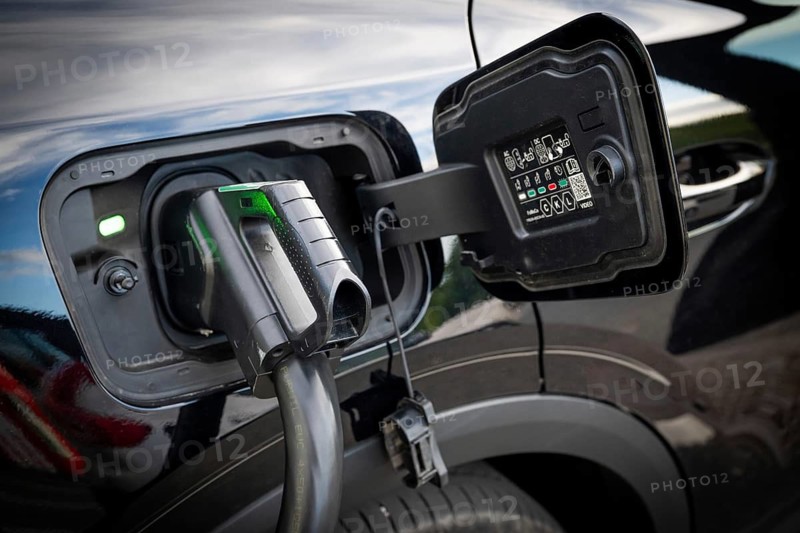 Fully electric Ford Explorer is being charged, charging cable in electric tank, charging station for electric vehicles, Norway