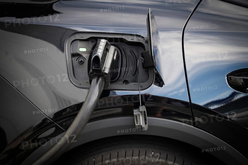 Fully electric Ford Explorer is being charged, charging cable in power tank, charging station for electric vehicles, Norway