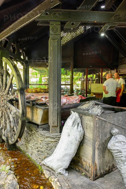 Two men supervise the cooking of roast lamb at water powered rotisseries in a tourist restauarant in Jablanica, Herzegovina-Neretva Canton, Bosnia and Herzevogina
