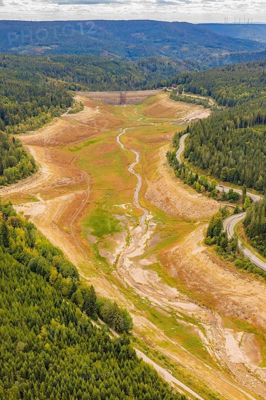 Aerial view of a dry riverbed surrounded by dense forests and hills, rehabilitation of the Schwarzenbach Reservoir, Forbach, Black Forest, Germany