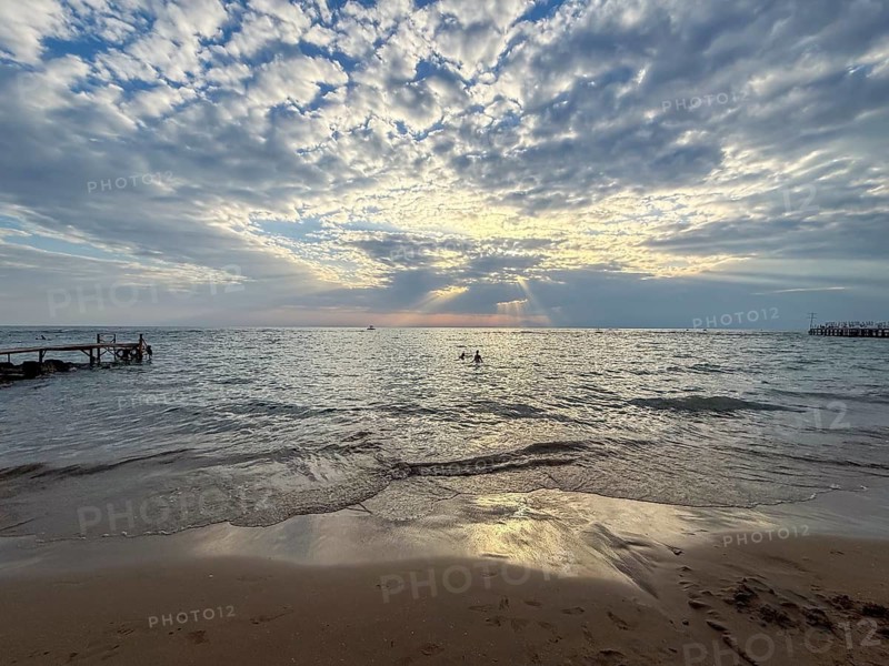 Sunset over the sea, broken cloud cover allows rays of light to fall on the water, Side, Manavgat, Antalya Province, Turkey