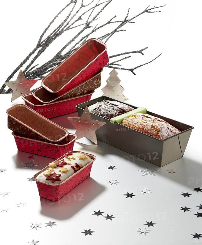 Various baking pans, branches and asterisks as decoration, against a white background, studio shot