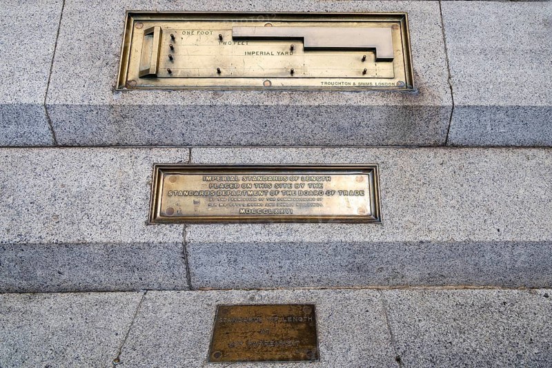 Brass plaques recording the Imperial Standards of Length are set into the granite steps at the wall and stairs of Trafalgar Square. Installed in 1876 by the Board of Trade, the markers once let the public verify imperial units of length. London, England, United Kingdom