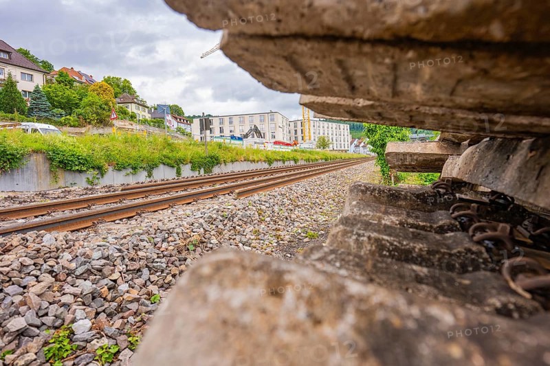 View along the railway tracks with focus on gravel and city buildings, station conversion electrification Leonhard Weiß, Waldshut. germany