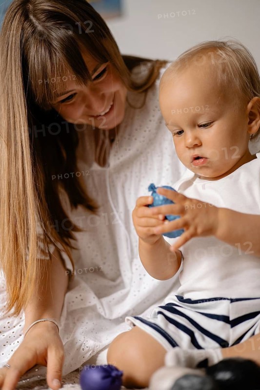 A mother and child play with toys together, creating a joyful and intimate atmosphere