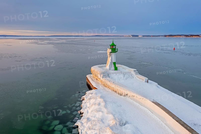 Ice covered Molenfeuer, frozen lighthouse, pier light on mole in Sassnitz harbour at sunrise in winter, Rügen Island, Mecklenburg-Vorpommern, Germany