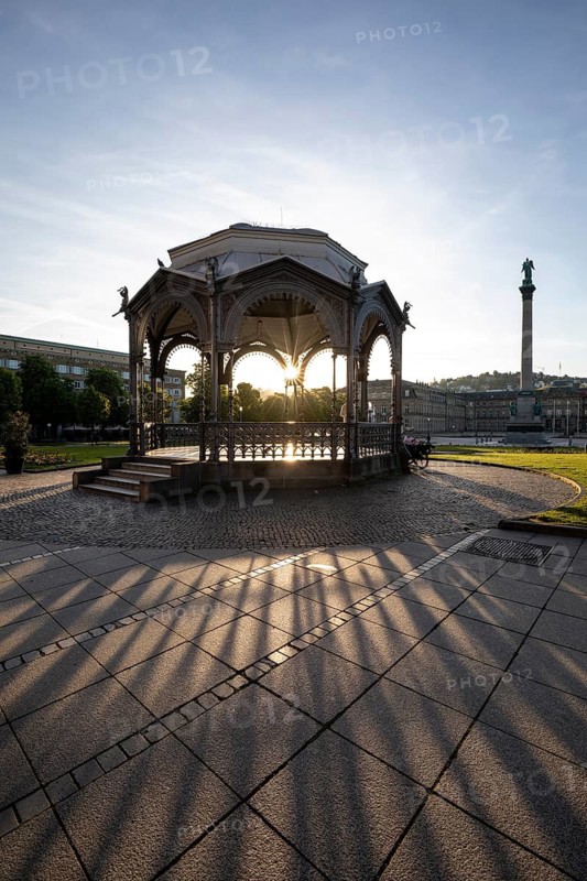 24.4.2026: The ornate cast iron music pavilion on Schlossplatz at sunrise. Sun star effect through the structure and long shadows on the pavement. Stuttgart, Baden Wuerttemberg, Germany