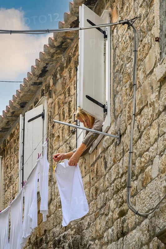 A woman hanging laundry to dry in Old Town, Split, Croatia
