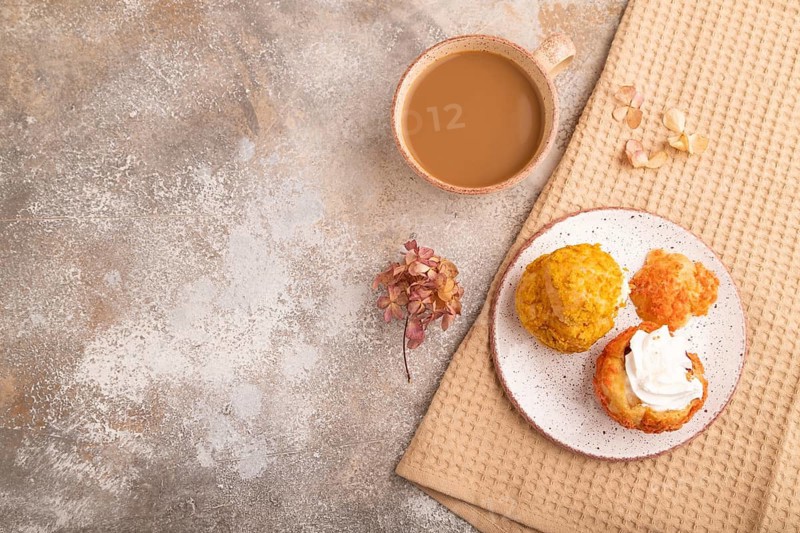 ?houx pastry with cup of coffee on brown concrete background with beige textile, copy space, top view, flat lay