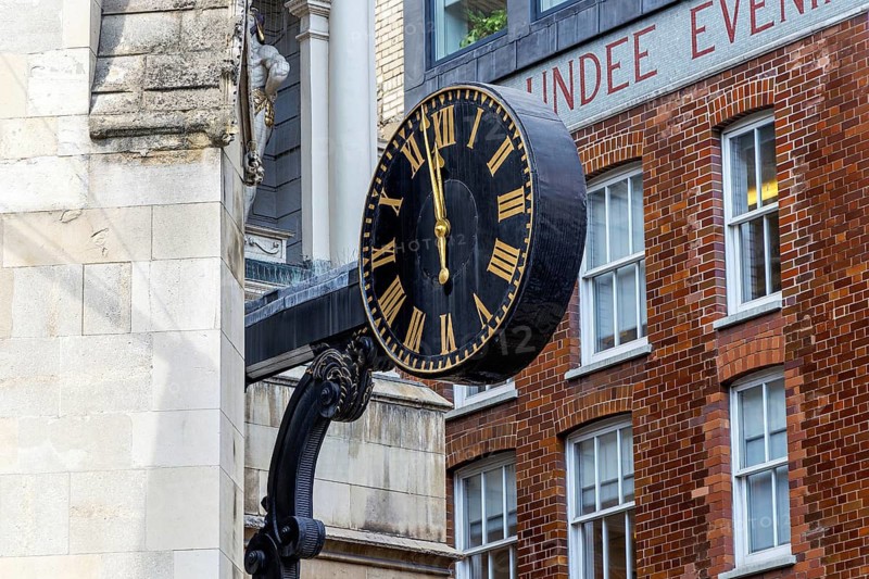 A black and gold clock projects from the tower of St Dunstan-in-the-West on Fleet Street, its mechanism dating from 1671 and once famous for a pair of striking figures traditionally called giants, removed in 1828 and returned to the church in 1935. London, England, United Kingdom