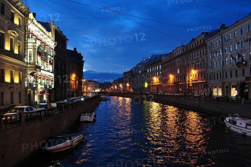 An atmospheric night scene with illuminated buildings that are reflected in the water of a river, the Moika, Saint Petersburg, St. Petersburg, Russia