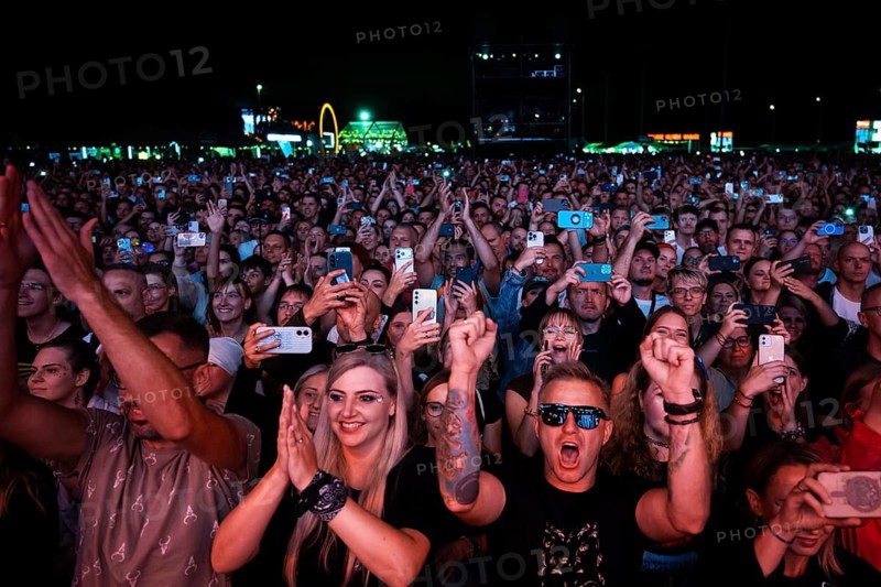 WROCLAW, POLAND - AUGUST 1, 2026: Large enthusiastic crowd enjoying a live outdoor music concert, with people raising their hands and recording the performance on smartphones