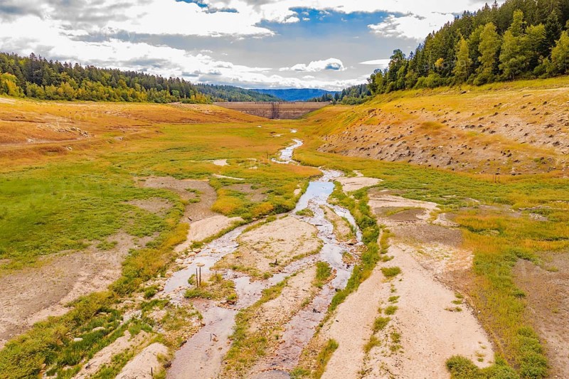 A winding river flows through the vast landscape of a green valley, rehabilitation of the Schwarzenbach Reservoir, Forbach, Black Forest, Germany