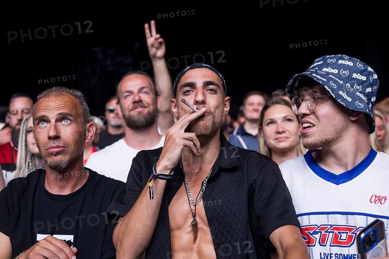 A festival goer pulls at a joint that Sido threw at him at the Klassentreffen festival on the Central Fairground in Berlin on 29.08.2026