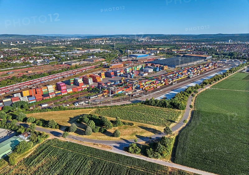 Aerial view of a large container terminal with freight trains, shipping containers, cranes, and rail logistics infrastructure surrounded by farmland. Kornwestheim, Baden-Württemberg, Germany