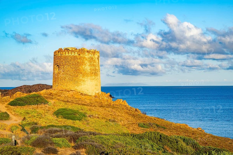 An old tower at the coast at Marinedda at sunset, Sardinia, Italy