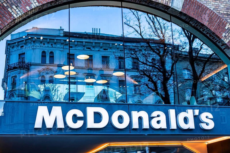 Vienna, Austria - 15 December, 2025: McDonalds restaurant entrance in Vienna, Austria. The sign is prominently displayed with a modern architectural design. Trees are visible in the background