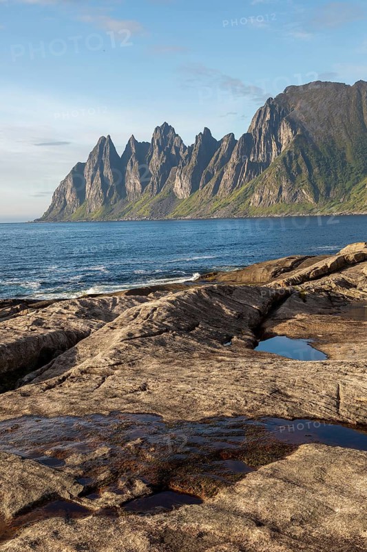Rocky coast of Tungeneset with distinctive devil teeth in the background during summer weather in northern Norway