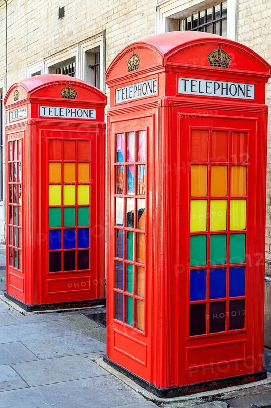 Two of the five red K2 telephone kiosks at Broad Court are seen close up, their windows fitted with colourful stained glass panels. Designed by Giles Gilbert Scott in 1927, the group was listed Grade II in 1986 as one of London's finest examples. London, England, United Kingdom