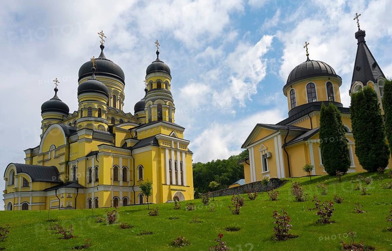 Orthodox church on green hill with yellow and black domes under blue sky, Hîncu monastery, Hâncu, Hâncul, Hincu, Hancu, Hancul, located near the village of Bursuc, Nisporeni district, Republic of Moldova, Moldova