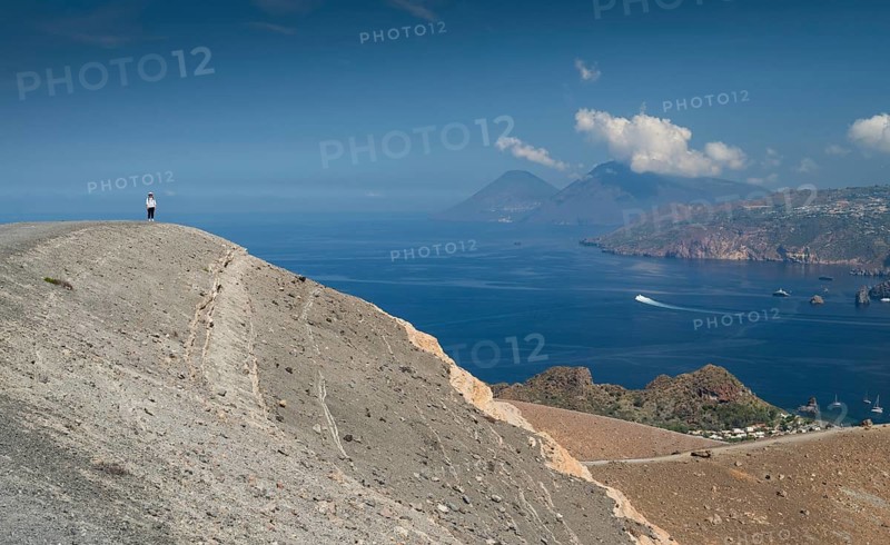 Visitor standing at the crater rim, Vulcano, in the background Lipari and Salina, Aeolian or Lipari Islands, Sicily, Southern Italy, Italy