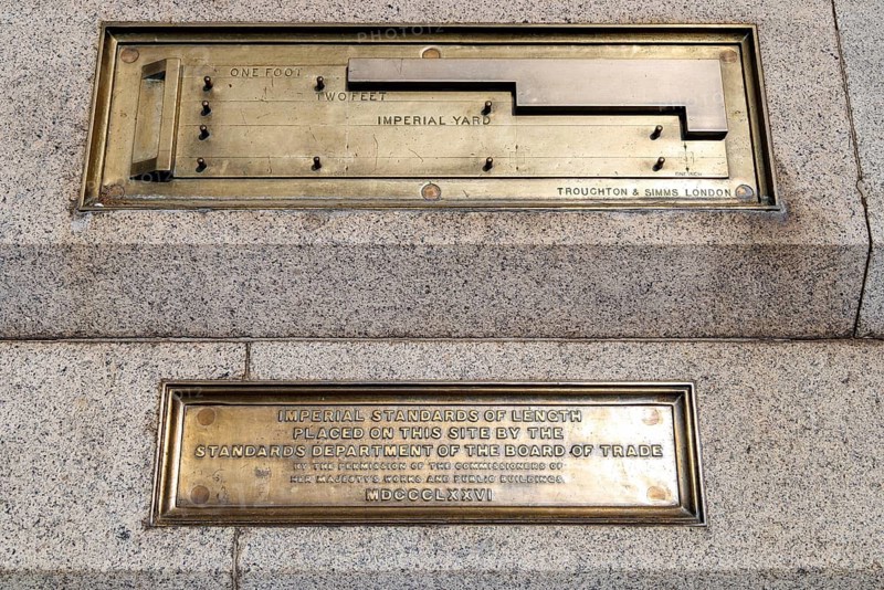 A brass Imperial Standard Yard measure and its inscription plaque form part of the Imperial Standards of Length set into the wall and stairs of Trafalgar Square. Installed in 1876 by the Board of Trade, the standards ensured uniform measurement across Britain. London, England, United Kingdom