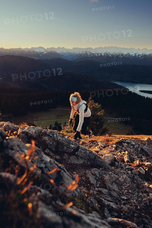 Trail running in autumn on the Jochberg on Lake Walchensee against the wonderful backdrop of the Alps, Bavaria, Germany