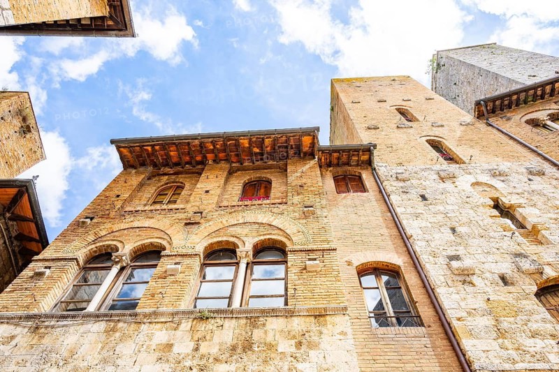 Towers of the old Town with historic buildings from Piazza del Duomo at San Gimignano on a sunny day, Tuscany, UNESCO World Heritage, Italy, Europe, Europe