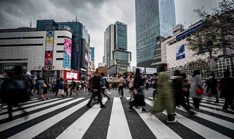 Crowd crossing zebra crossing on a large intersection, motion blur, back modern houses with colorful neon signs, long exposure, Shibuya Crossing, Shibuya, Tokyo, Japan
