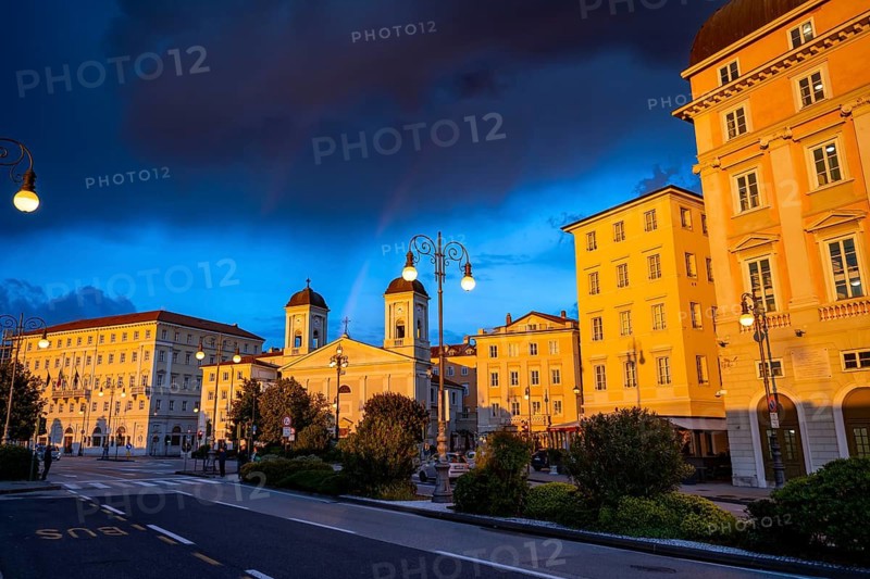 Magnificent buildings and palazzos on the Riva del Mandracchio seaside promenade in the evening light at sunset, Greek Orthodox church San Nicolò, dramatic clouds, Trieste, Friuli-Venezia Giulia region, Italy
