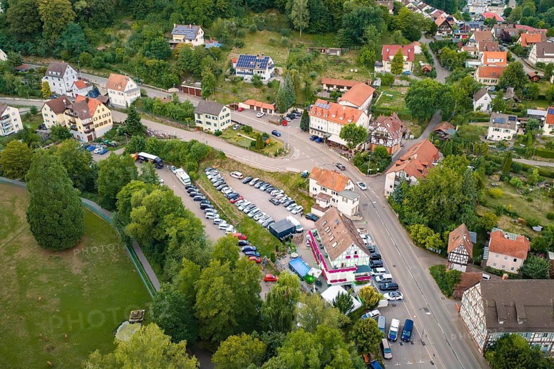 Aerial view of a village with roads, parked cars and surrounding green landscape, Calwer Klostersommer Festival, Hirsau Abbey, Calw, Black Forest, Germany