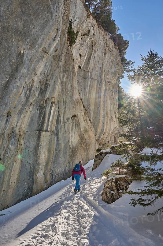 Woman hiking in the snowy mountain landscape of the Alpstein Säntis mountain range, Brülisau, Kanton Appenzell, Switzerland