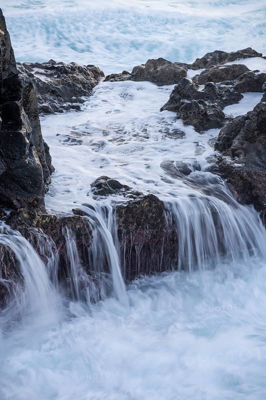 Lava rocks in the ocean, washed by waves. Charco Verde, La Palma, Canary Islands, Spain