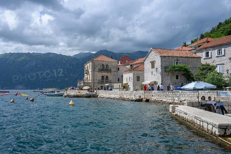 Tourists stroll along the waterfront at Boka Kotor bay (Boka Kotorska), Perast, Montenegro