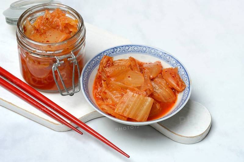 Kimchi, fermented vegetables in glass container and bowl