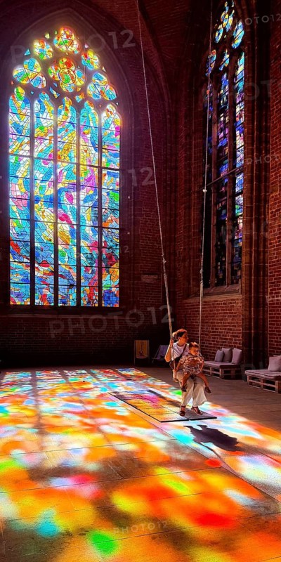 Sky swing in the town church of Our Dear Women, installation by Mario Haunhorst with stained glass windows by Alfred Manessier with the title Blessed swing, believe, hope, love at your own risk, Bremen, Germany