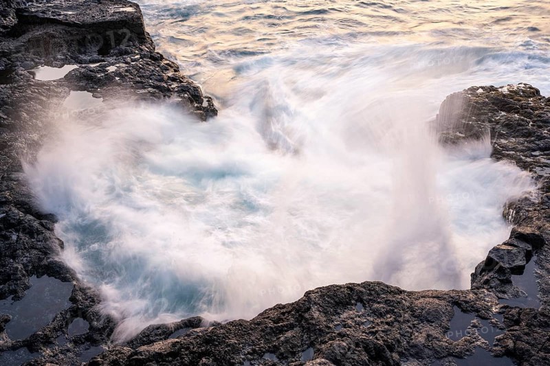 Seawater flows over lava rocks into a small pool. Long exposure, morning light. Coast near Puerto de Talavera, La Palma, Canary Islands, Spain