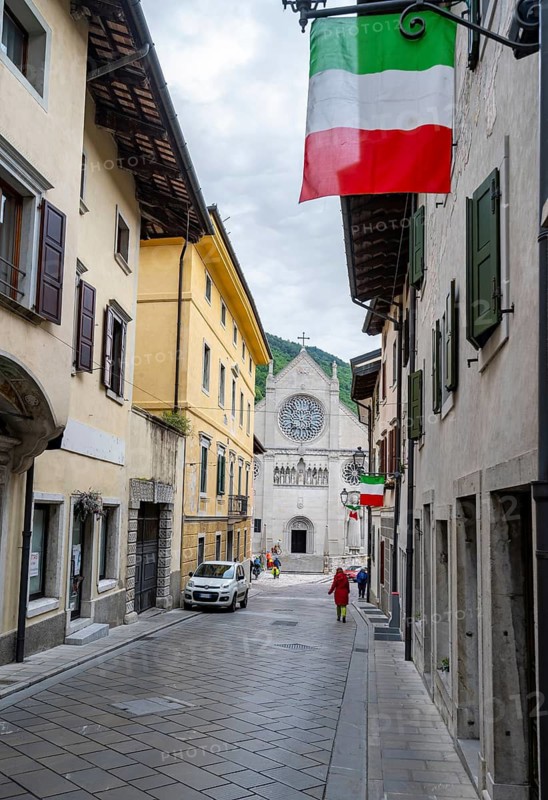 Street with Italian flags, Duomo di Santa Maria Assunta church in the back, Gemona del Friuli, Friuli-Venezia Giulia, Italy