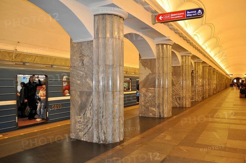 Well-lit subway station with massive marble columns and a blue train, metro, Saint Petersburg, St. Petersburg, Russia