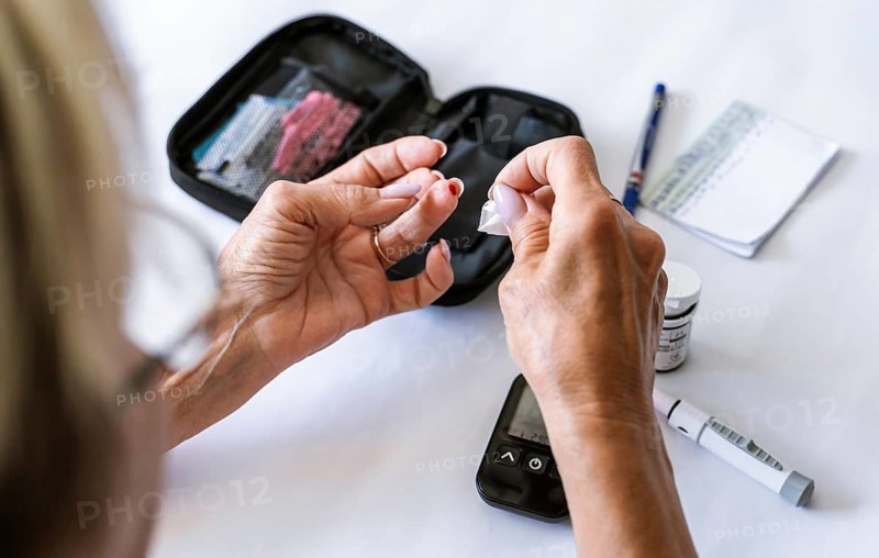Woman preparing a lancet device for blood glucose testing at home. Diabetes self-care, medical procedure, endocrinology, healthcare routine, prevention and chronic disease management concept