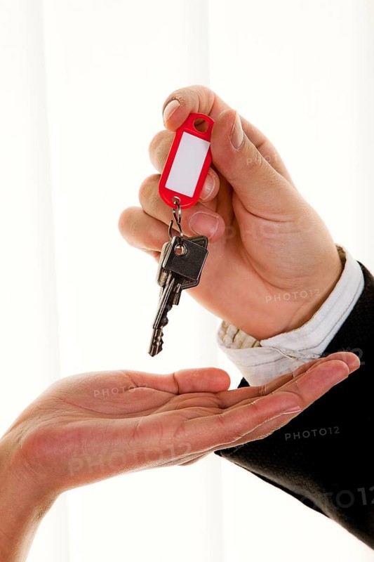 Successful real estate agent hands over the key to an apartment to a woman, realtor, landlord, tenant
