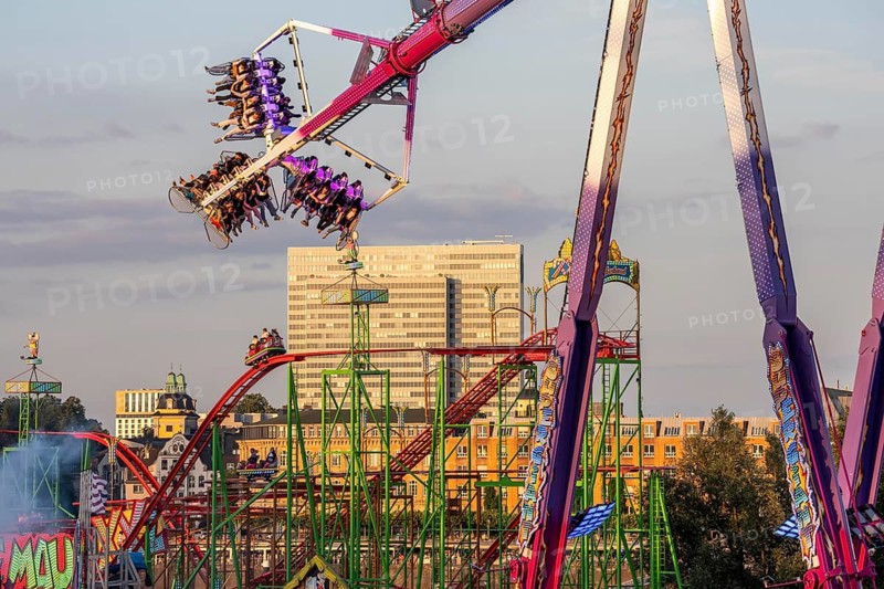 Rheinkirmes in den Rheinwiesen in Düsseldorf-Oberkassel, Infinity ride, the highest mobile overhead swing in the world with a height of 65 meters, Dreischeibenhaus, Wilde Maus rollercoaster, North Rhine-Westphalia, Germany
