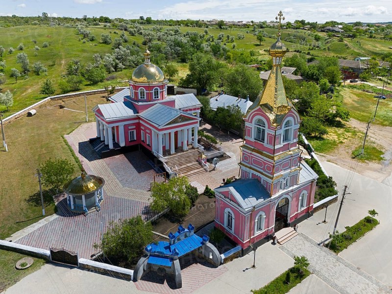 Orthodox village church with bell tower and golden domes nestled in green hills and roads, aerial view, St. George church, Cazaclia, Kazayak, Ceadîr-Lunga district, Ceadir-Lunga, Chadyr-Lunga, Gagauzia autonomous region, Republic of Moldova, Moldova