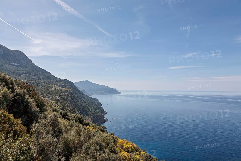 View of coastal landscape with mountains and calm blue sea under a wide sky, Northwest Coast, Majorca, Balearic Islands, Spain